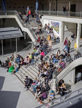 20 Ekim 2023 'te Portekiz' in Porto şehrinde Bolhao Marketi 'nin merdivenlerinde oturan genç insanlar yiyip içiyorlar.