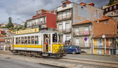 Porto, Portekiz 'de 21 Ekim 2023 tarihinde yolcu taşıyan klasik sarı Porto tramvayı