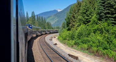 Rocky Dağları lüks treni 3 Haziran 2023 'te Rocky Dağları, Britanya Kolumbiyası, Kanada' da virajı dönüyor.