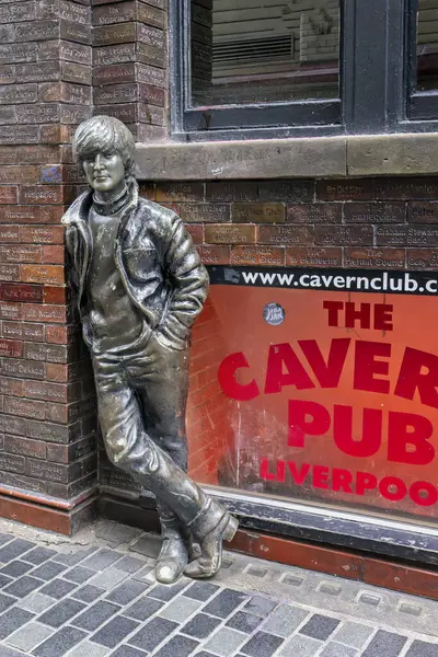 20 Mayıs 2024 'te Matthew Street, Liverpool, Merseyside, İngiltere' deki Mağara Barı 'nın önündeki duvara dayanan John Lennon' ın bronz heykeli