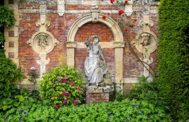 İngiltere 'nin Suffolk kentindeki Somerleyton Hall' da çiçeklerle çevrili Sheperdess heykeli 16 Haziran 2024 'te