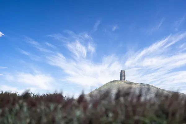 stock image Close up of Glastonbury Tor on hilltop seen from the Somerset Levels, Ham Wall, Somerset, UK on 23 August 2024