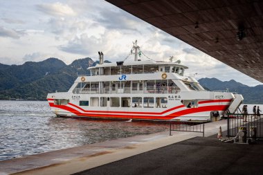 Ferry to Miyajima Island near Hiroshima offloading passengers at  Miyajimaguchi dock in Hiroshima, Japan on 29 September 2024 clipart