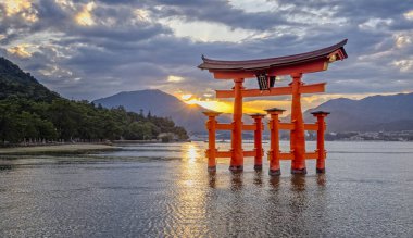 Iconic turuncu Torii kapısı 29 Eylül 2024 'te Japonya' nın Miyajima Adası 'nda gün batımında Itsukashima türbesi yakınlarında denizde yüzer.
