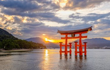 Iconic turuncu Torii kapısı 29 Eylül 2024 'te Japonya' nın Miyajima Adası 'nda gün batımında Itsukashima türbesi yakınlarında denizde yüzer.
