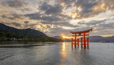 Iconic turuncu Torii kapısı 29 Eylül 2024 'te Japonya' nın Miyajima Adası 'nda gün batımında Itsukashima türbesi yakınlarında denizde yüzer.