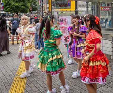 Tokyo, Japonya 'da 6 Ekim 2024' te parlak renkli mini etekli genç Japon kızlar Tik tok müzik reklamı yapıyorlar.