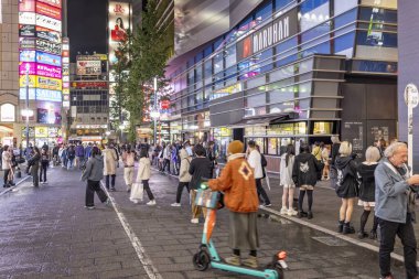 Crowded Kabukicho district at night with brightly lit buildings and advertising displays in Tokyo, Japan on 9 October 2024, clipart