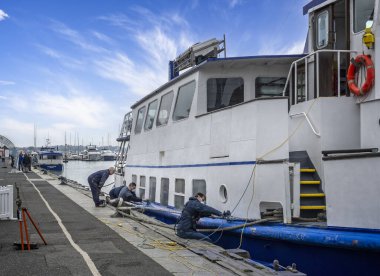 Workers sanding down the metalwork ready for repainting the Solent Scene, a large tour boat moored at Poole Quay, Dorset, UK on 14 November 2024 clipart