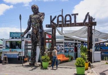 Giant African warrior sculpture made out of recycled metal outside entrance to beach restaurant at Kaai 4, Mossel Bay, South Africa on 18 December 2024 clipart