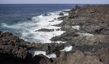 Dalgalar 7 Şubat 2025 tarihinde İspanya, Lanzarote, Los Hervideros 'taki doğal kemerlerle engebeli volkanik kıyılara çarpar.