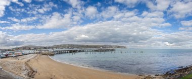 13 Mart 2025 'te Swanage, Dorset, İngiltere' de Swanage ve Pier 'in dramatik gökyüzü panoramik görüntüsü