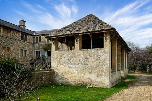 25 Mart 2025 'te Lacock, Wiltshire, İngiltere' deki Tanyard 'a bağlı antik taş çatılı ahır.