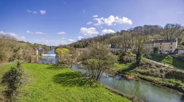 Avon Nehri 'nin panoramik manzarası The Cross Guns barı ve Avon, Wiltshire, İngiltere yakınlarındaki Avoncliff' teki su kemerinden 29 Mart 2025 'te