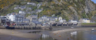 Barmouth kasabasının panoramik manzarası ve 9 Nisan 2025 'te Barmouth, Gwynedd, İngiltere' de sular çekildiğinde liman manzarası