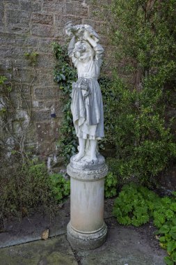 8 Nisan 2025 'te Galler, Powys, Galler yakınlarındaki Powis Kalesi' nde kafasında tavuk olan genç bir kızın heykelini kapatın.