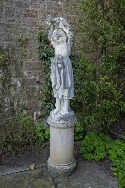 8 Nisan 2025 'te Galler, Powys, Galler yakınlarındaki Powis Kalesi' nde kafasında tavuk olan genç bir kızın heykelini kapatın.