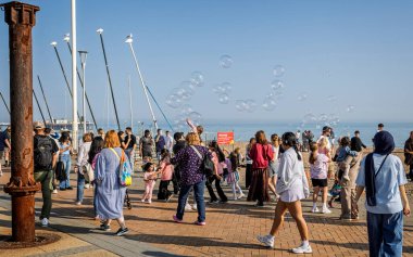 Çocuklar 27 Nisan 2025 'te İngiltere' nin Brighton plajında büyük kabarcıklarla eğleniyorlar.