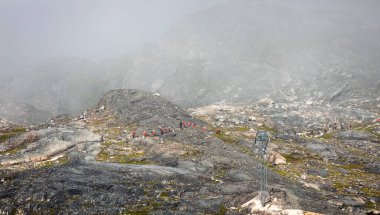 13 Temmuz 2013 'te Grönland' ın Qaqortoq kenti yakınlarındaki sisli bölgede Kuzey Kutbu 'nda yürüyüş yapan aylaklar.