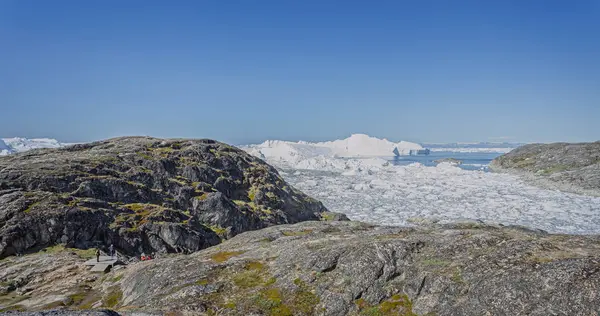 Ilulissat, 17 Temmuz 2022 'de Grönland' ın Ilulissat kentinde turistlere ölçek duygusu veren buzul heykeli.