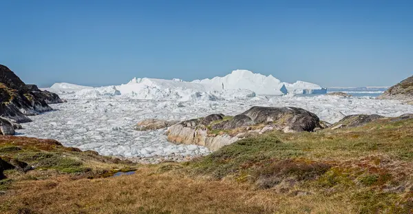 17 Temmuz 2022 'de Grönland' ın Ilulissat kentindeki karadan görülen Ilulissat buzullarındaki büyük buzdağları