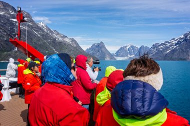 Hurtigrutens Fridtjof Nansen gemisindeki bir grup turist 19 Temmuz 2022 'de Grönland' ın Evighedsfjord kentindeki buzullara ve srctic dağlarına hayran kaldılar.