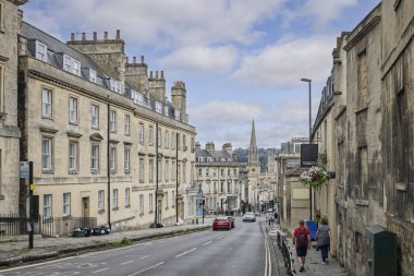 31 Temmuz 2025 'te Bath, Somerset, İngiltere' de Bath Abbey ile Broad Caddesi 'ndeki St. Miachael Kilisesi manzarası