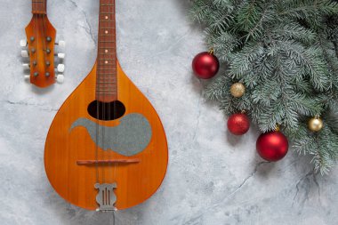 Noel dekorlu eski mandolin ve köknar ağacı dalları. Noel ve Yeni Yıl konsepti. Üst görünüm, hafif mermer arka planda yakın plan