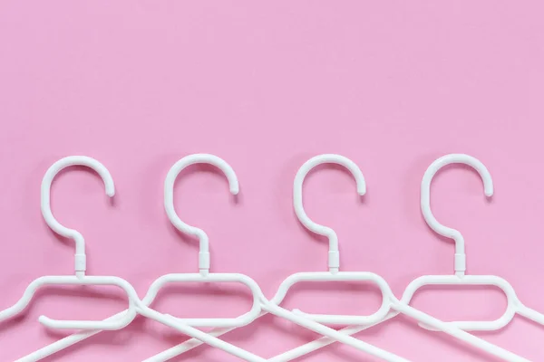 White Plastic Hangers Pink Background Concept Sale Shop Second Hand — Stock Photo, Image