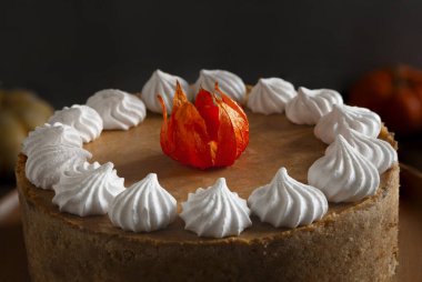 Sıcak sonbahar arka planında kremalı balkabağı peynirli kek..