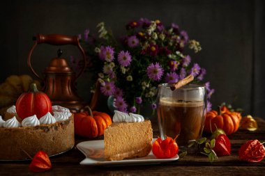 Sıcak sonbahar arka planında kremalı balkabağı peynirli kek..