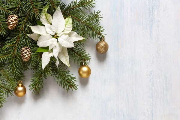 Noel süsleri, köknar ağacı dalları, beyaz noktalar, altın renkli Noel topları ve açık mavi arka planda koniler. Üst manzara, kapat, düz yat.