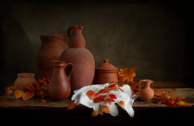 Parlak sonbahar yaprakları ve eski tarz kil sürahilerle dolu bir hayat.