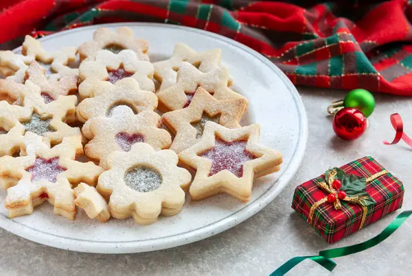 Traditional Tasty Homemade Linzer cookies with jam and Christmas decorations.	