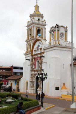 Chignahuapan Puebla, Meksika - 7 Eylül 2014: Renkli ahşap bir büfesi ve Parroquia de Santiago Apostol kilisesi olan Plaza de Armas, parlak renkli cepheleriyle, Noel için küreler satın alınabilecek bir yer