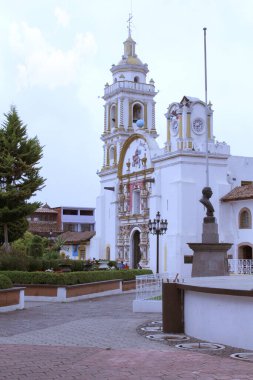 Chignahuapan Puebla, Meksika - 7 Eylül 2014: Renkli ahşap bir büfesi ve Parroquia de Santiago Apostol kilisesi olan Plaza de Armas, parlak renkli cepheleriyle, Noel için küreler satın alınabilecek bir yer