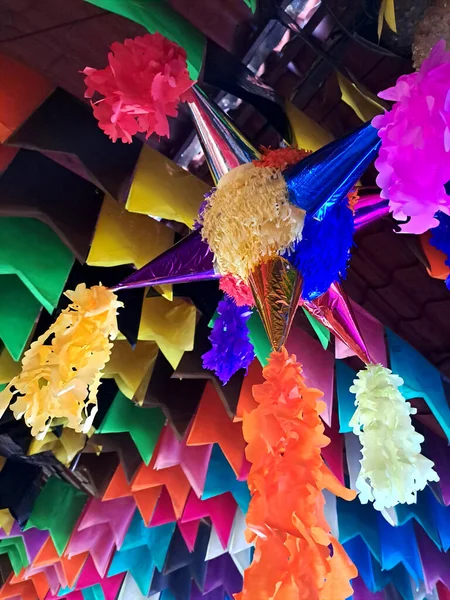 Mexican party piata made with a clay or cardboard pot covered in colored paper, with seven spikes, containing fruits and sweets, hung on a string to be broken with a stick on birthdays or Christmas