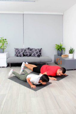 Overweight Latino dad and son exercise at home to lose weight and be healthy to avoid diseases such as diabetes or hypertension