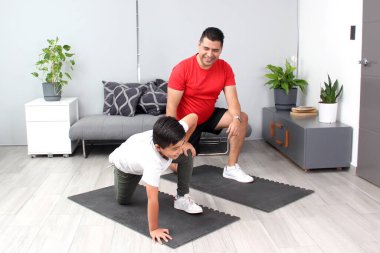 Overweight Latino dad and son exercise at home to lose weight and be healthy to avoid diseases such as diabetes or hypertension