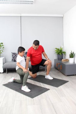 Overweight Latino dad and son exercise at home to lose weight and be healthy to avoid diseases such as diabetes or hypertension