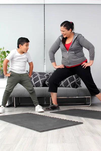 Latino mom and son exercise at home to lose weight and be healthy to avoid diseases such as diabetes or hypertension