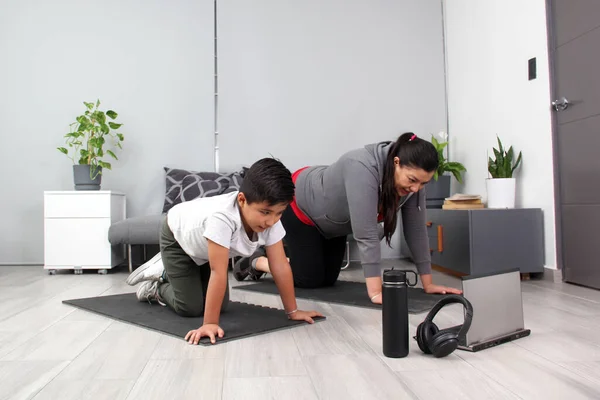 Latino mom and son exercise at home to lose weight and be healthy to avoid diseases such as diabetes or hypertension