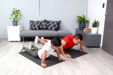 Overweight Latino dad and son exercise at home to lose weight and be healthy to avoid diseases such as diabetes or hypertension