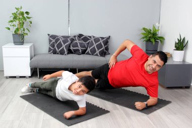 Overweight Latino dad and son exercise at home to lose weight and be healthy to avoid diseases such as diabetes or hypertension