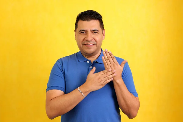 暗い髪ラテン系の成人男性は 彼の社会環境とのコミュニケーションのチャネルを確立するために聴覚障害者の典型的な手話を使用しています — ストック写真