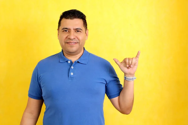 Dark-haired Latino adult man uses sign language typical of deaf people to establish a channel of communication with his social environment