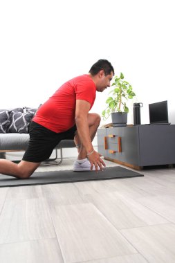 Overweight latina adult man exercises inside his home in his living room via computer online to be healthy