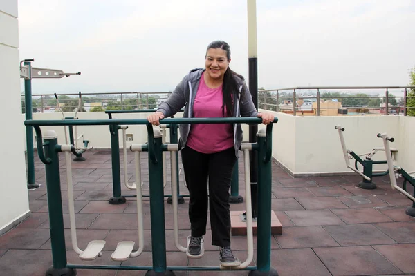 라티나 여성은 장비를 가지고 아파트 지붕에 체육관에서 운동을 — 스톡 사진