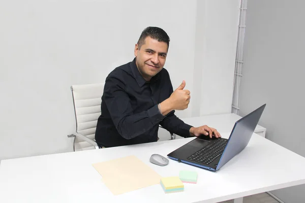 남자는 자신의 사무실에서 노트북을 가지고 일하고 행복해 이유는 자신의 승리의 — 스톡 사진
