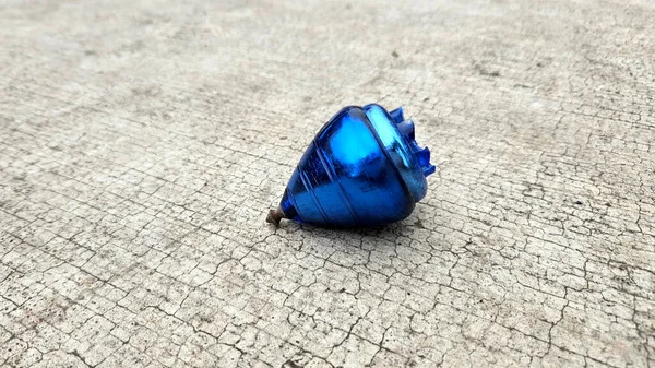 Blue spinning top, toy for children and adults, a type of spinning top that can rotate on one end, its gravitational center with a gyroscopic effect